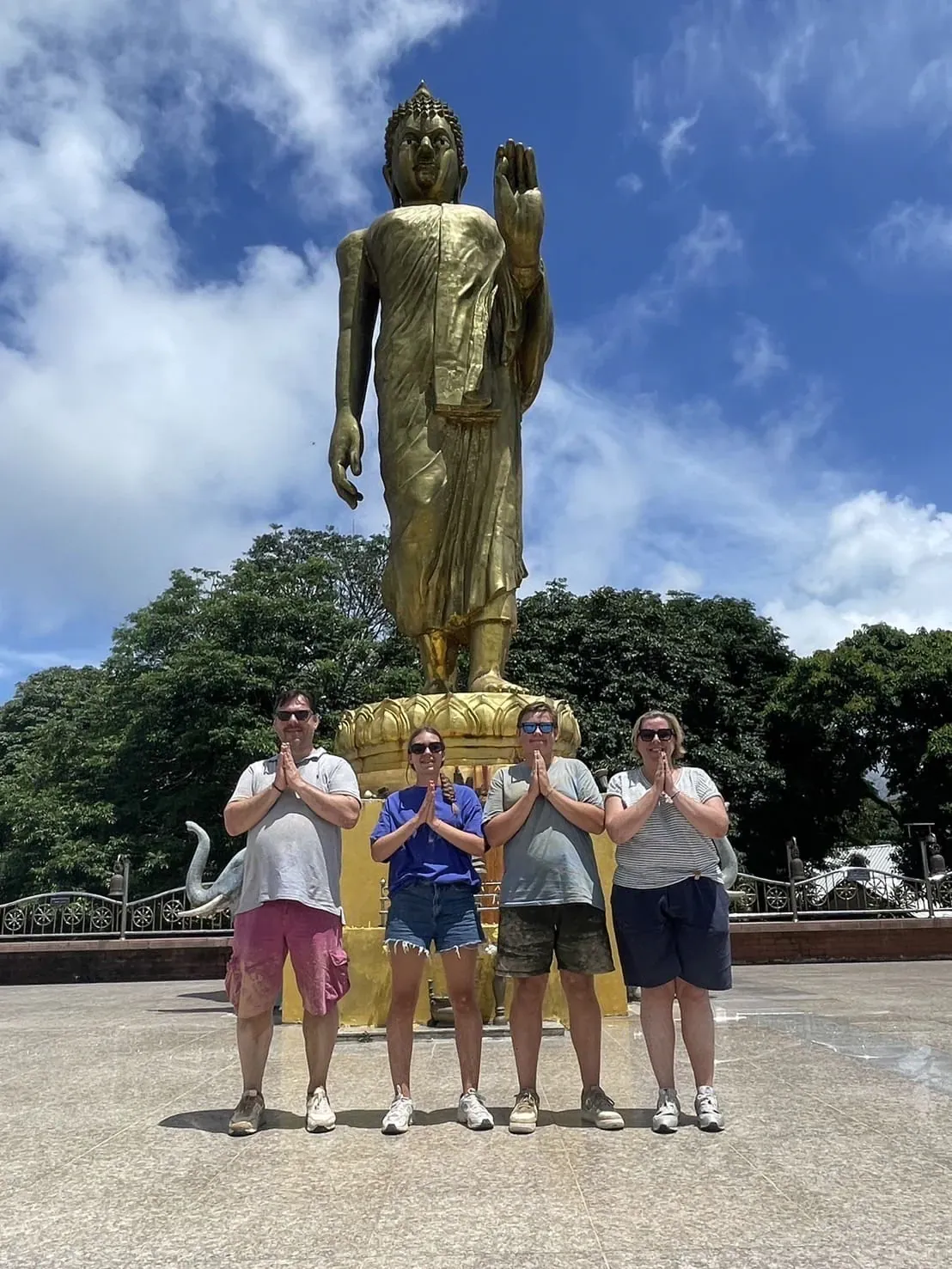 Visitors paying respects in front of the golden Buddha statue at Wat Teepangkorn