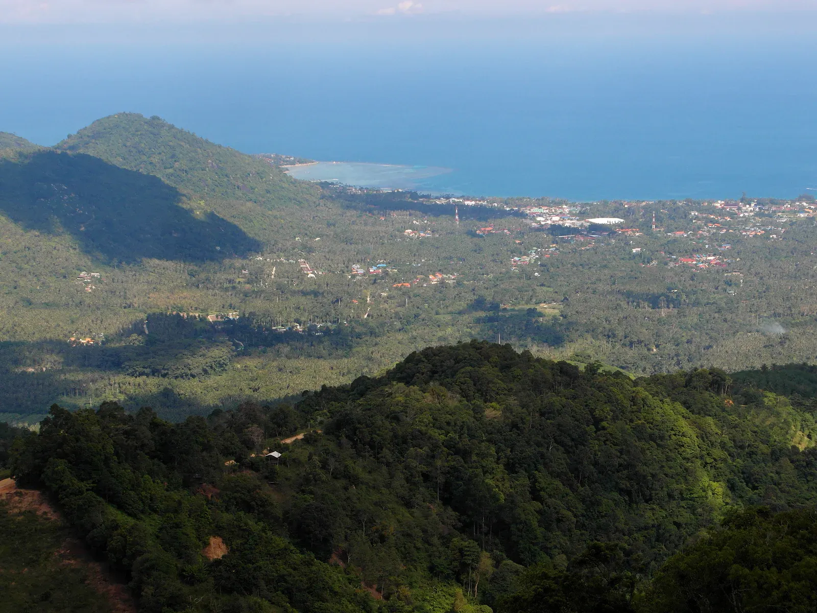 Koh Samui's green hills rolling down to the coast and the sea, seen from the terrace of Wat Teepangkorn
