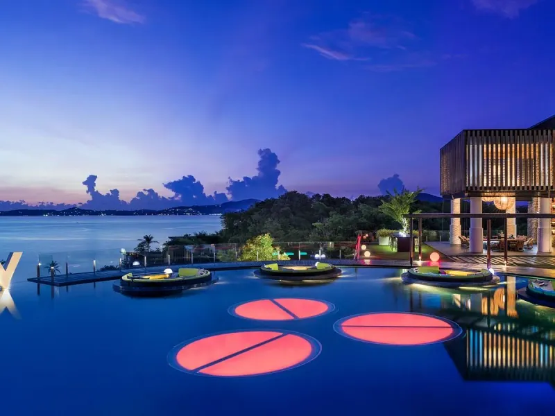 Glowing pool pods and a deep blue evening sky at Woobar, W Koh Samui